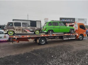 Grúa cargando autos Renault 4 tuneados
