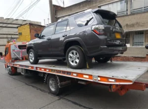 Grúa cargando camioneta gris