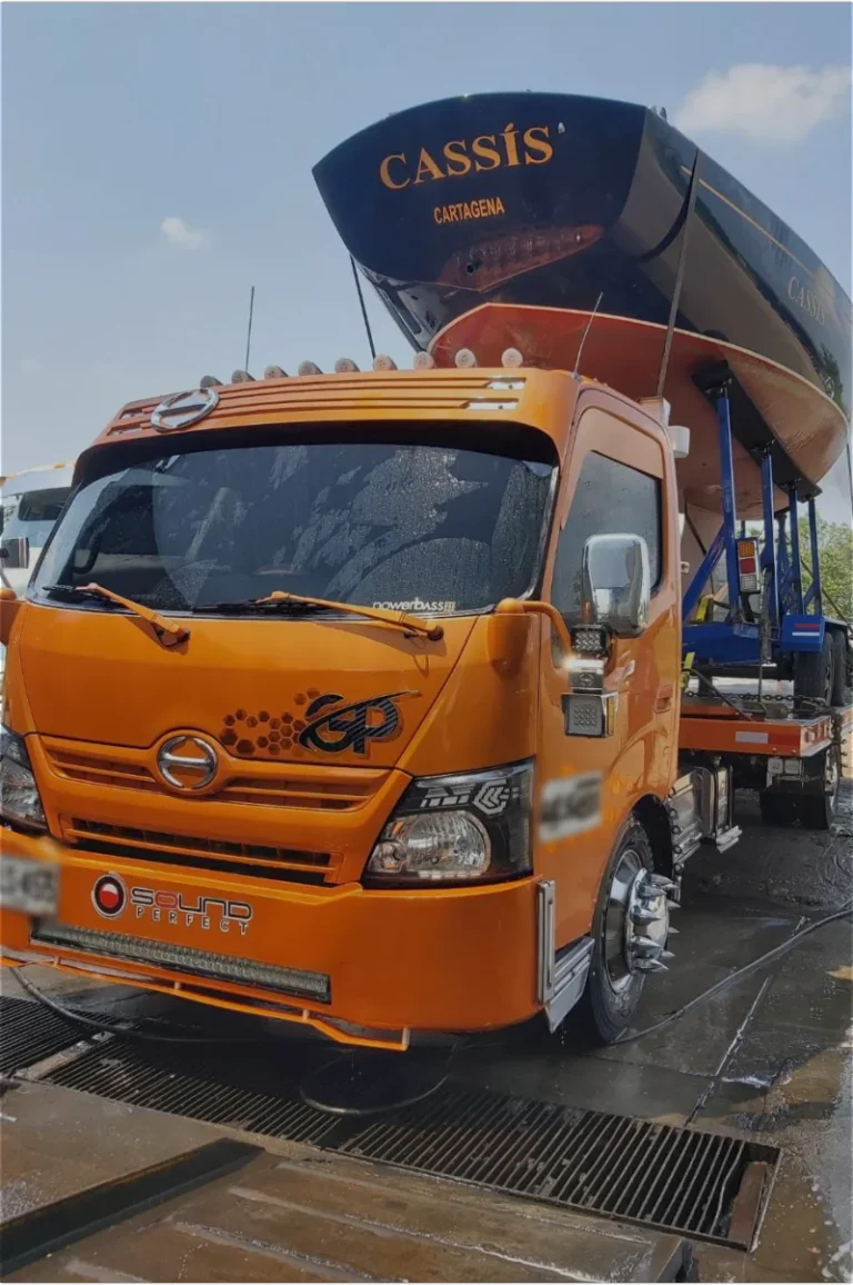 Grúa naranja cargando una lancha