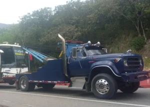 Grúa tipo pluma remolcando un bus